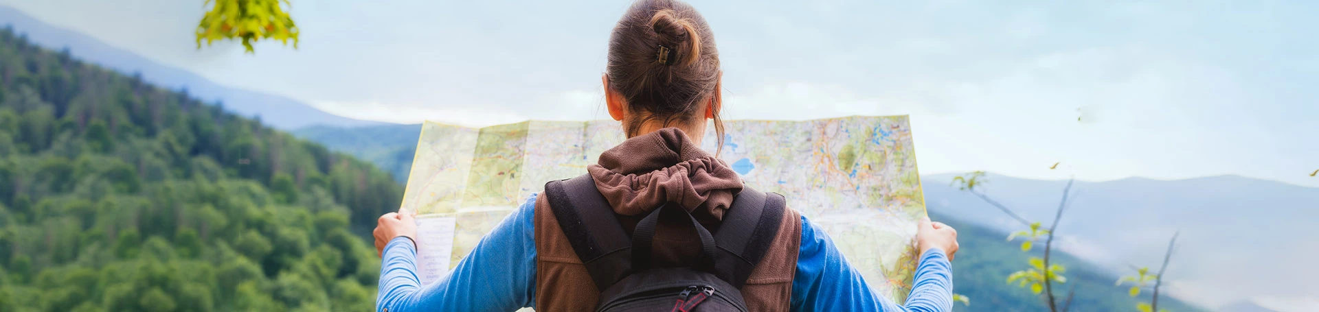 dziewczyna w górach, czytająca mapę.